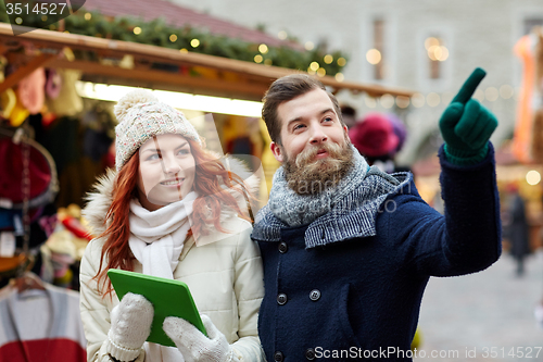 Image of happy couple walking with tablet pc in old town