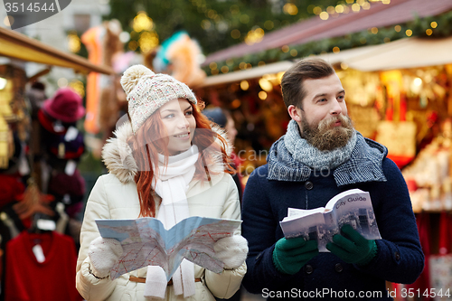 Image of happy couple with map and city guide in old town