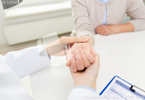 Image of doctor checking senior woman pulse at hospital