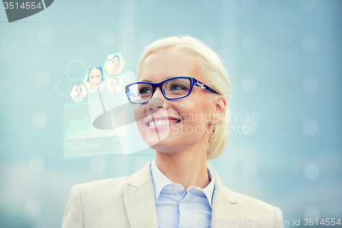 Image of young smiling businesswoman in eyeglasses outdoors