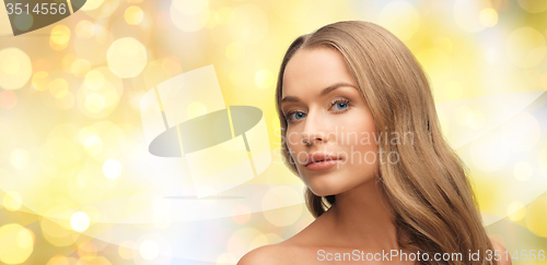 Image of beautiful young woman face over yellow lights