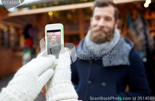 Image of couple taking picture with smartphone in old town