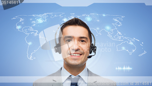 Image of smiling businessman in headset over world map