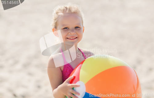 Image of happy little girl playing inflatable ball on beach