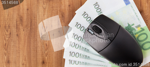 Image of close up of computer mouse and euro money