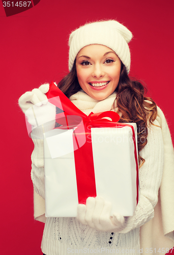 Image of smiling woman in white clothes with gift box