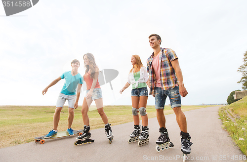 Image of happy teenagers with rollerblades and longboards