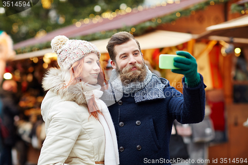 Image of couple taking selfie with smartphone in old town