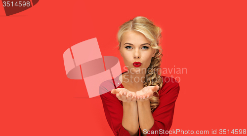 Image of woman blowing something on palms of her hands