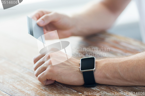 Image of close up of hands with smart watch and credit card