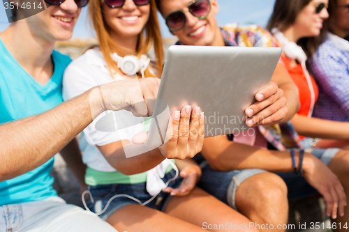 Image of group of smiling friends with tablet pc outdoors