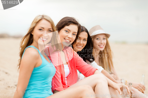 Image of smiling girls with drinks on the beach