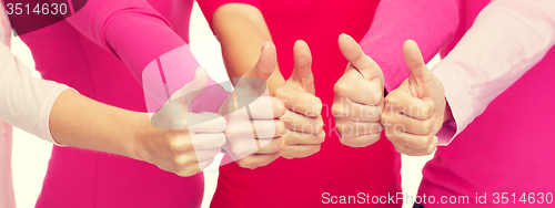 Image of close up of women in pink shirts showing thumbs up