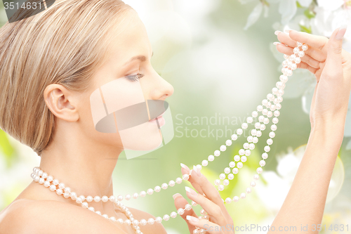 Image of woman with pearl necklace over cherry blossom