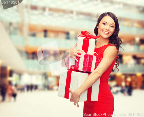 Image of smiling woman in red dress with gift boxes