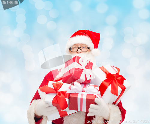 Image of man in costume of santa claus with gift boxes