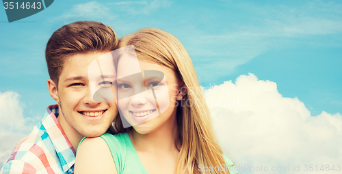 Image of smiling couple hugging over blue sky background
