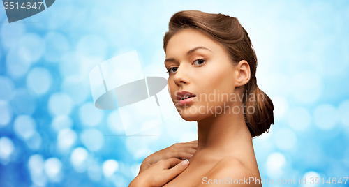 Image of woman with bare shoulders over blue lights