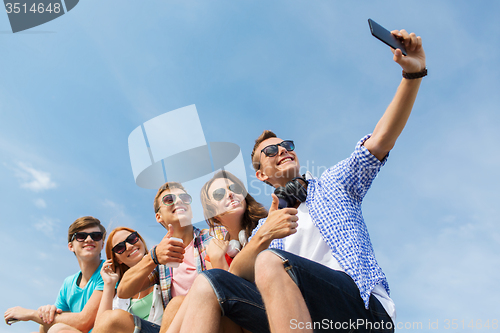 Image of happy friends with smartphone taking selfie