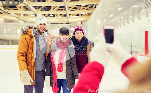 Image of happy friends taking photo on skating rink