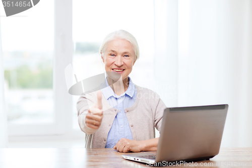 Image of happy senior woman with laptop showing thumbs up