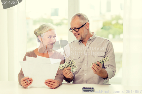 Image of senior couple with money and calculator at home