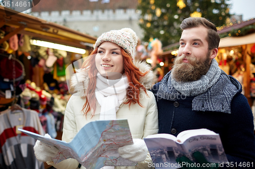 Image of happy couple with map and city guide in old town