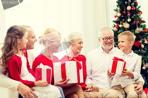 Image of smiling family with gifts at home