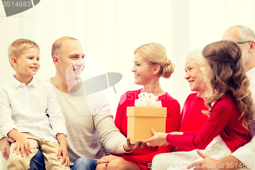 Image of smiling family with gift at home