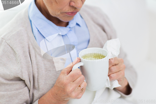 Image of close up of sick senior woman drinking tea at home