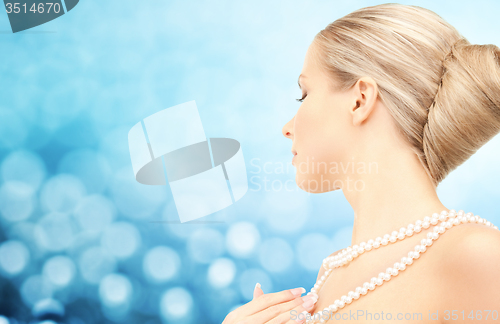 Image of beautiful woman with sea pearl necklace over blue