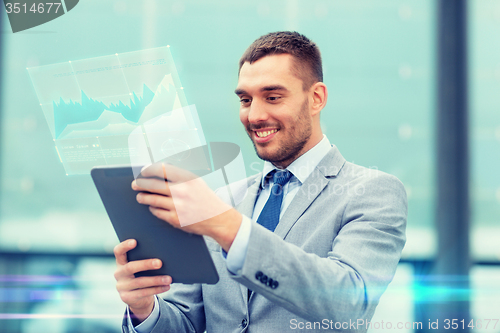 Image of smiling businessman with tablet pc outdoors