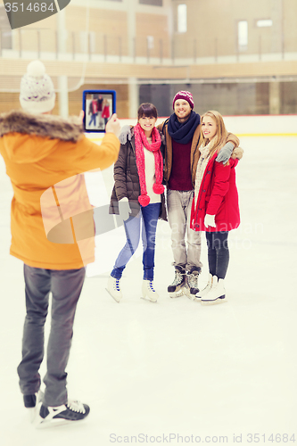 Image of happy friends taking photo on skating rink
