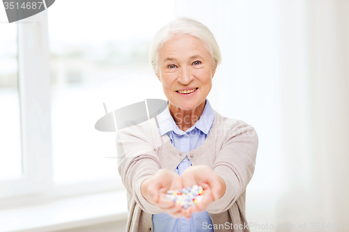 Image of happy senior woman with medicine at home