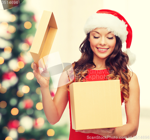 Image of smiling woman in santa helper hat with gift box