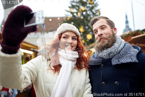 Image of couple taking selfie with smartphone in old town