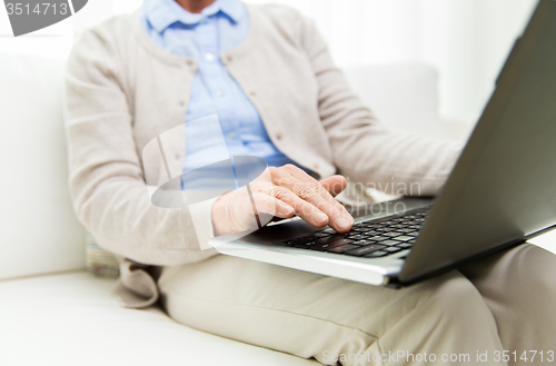 Image of close up of senior woman with laptop at home