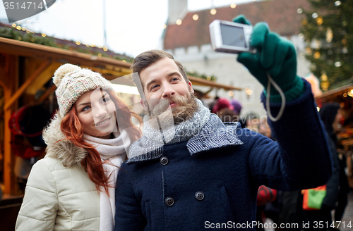 Image of couple taking selfie with smartphone in old town