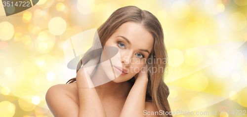 Image of beautiful young woman face over yellow lights