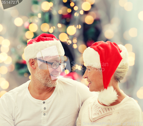Image of happy senior couple in santa helper hats