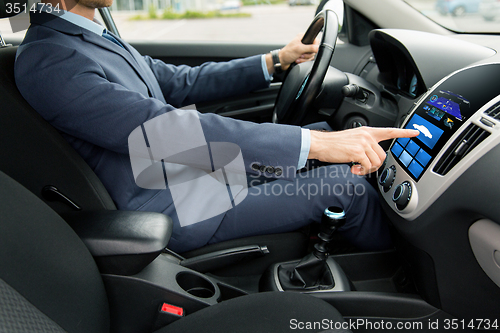 Image of close up of man driving car with board computer