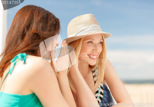 Image of girls gossiping in cafe on the beach
