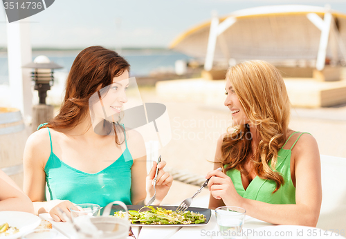 Image of smiling girls in cafe on the beach