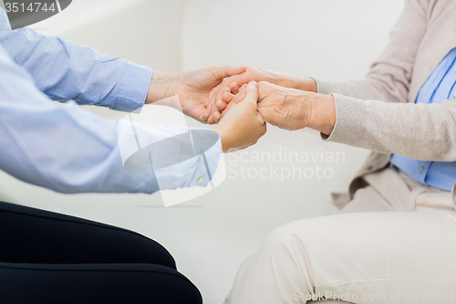 Image of close up of senior and young woman hands