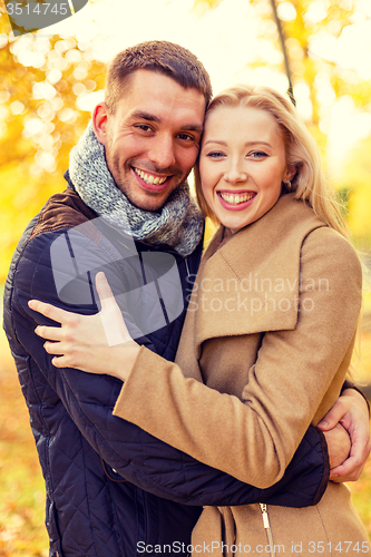 Image of smiling couple hugging in autumn park