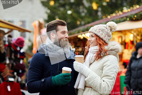 Image of happy couple drinking coffee on old town street