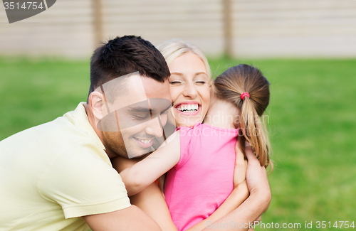 Image of happy family hugging outdoors