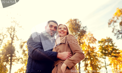 Image of smiling couple hugging in autumn park