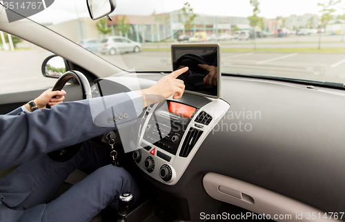 Image of close up of young man with tablet pc driving car