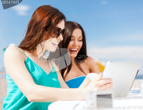 Image of girls looking at tablet pc in cafe